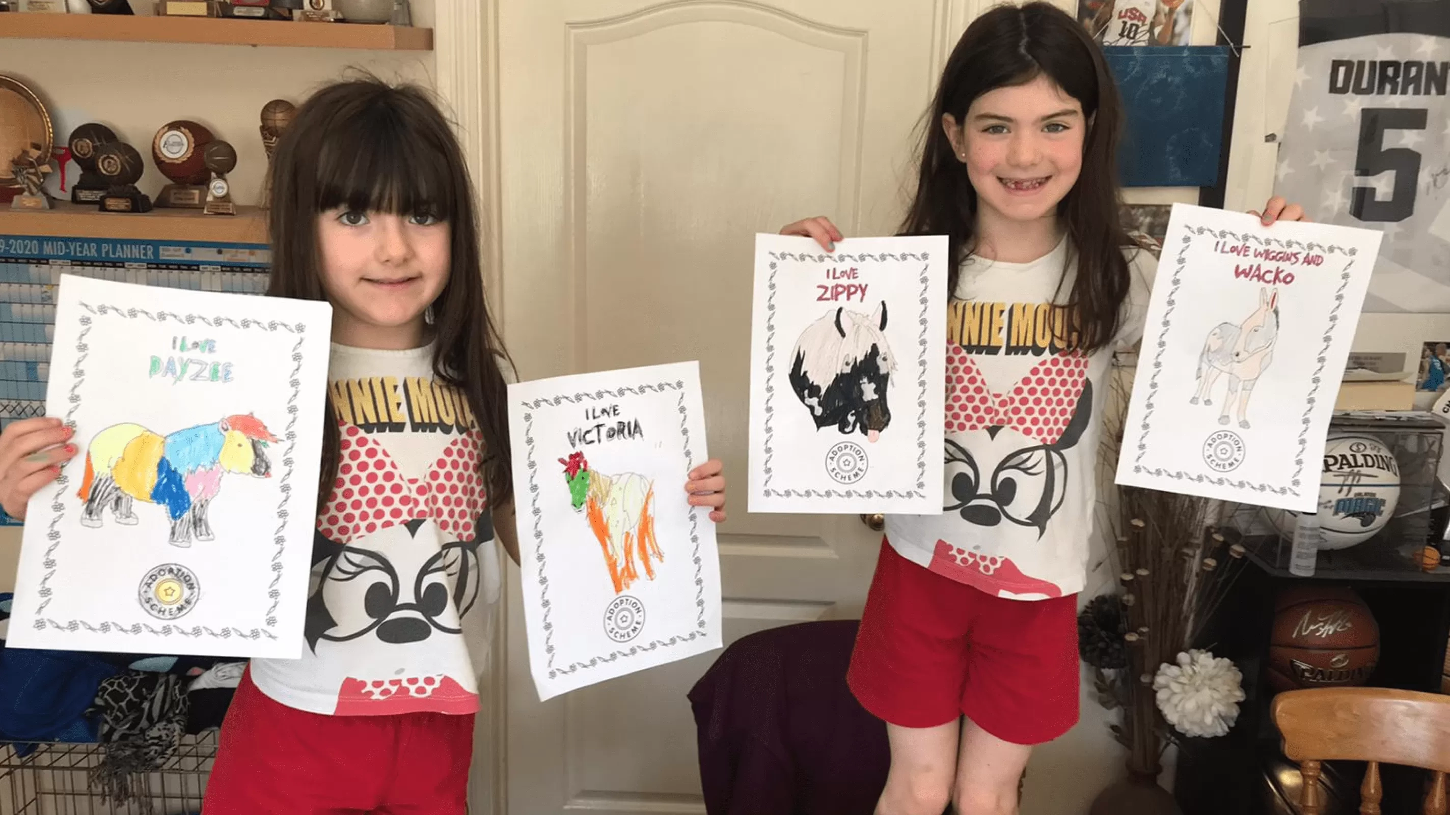 Two kids showcasing their Redwings drawing