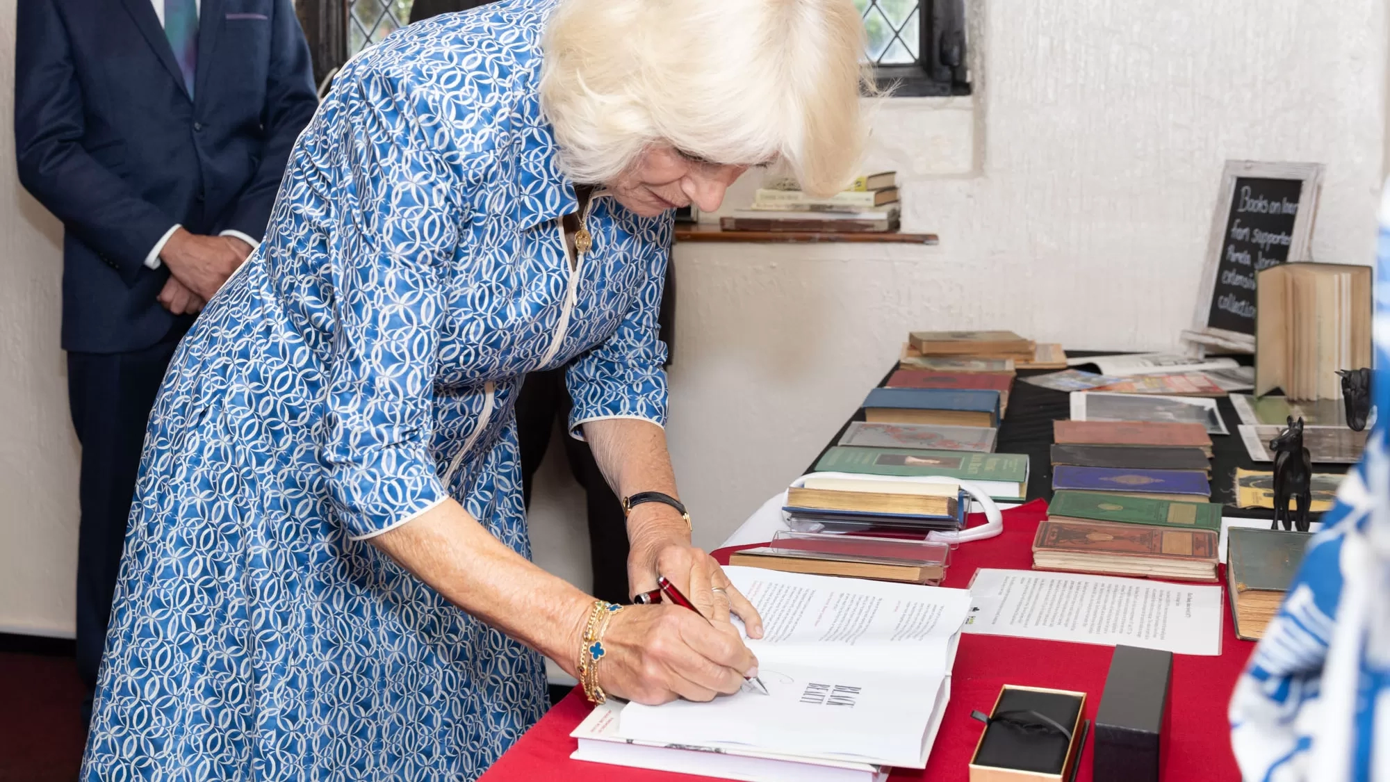 Queen Camilla signs a copy of Black Beauty at Anna Sewell House