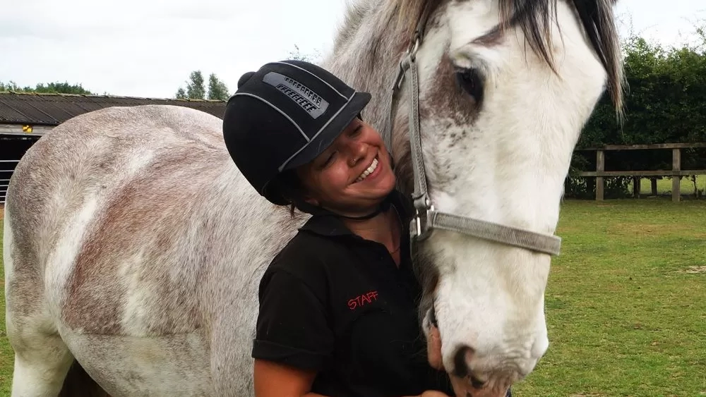 Talita smiles as she cuddles Boo in his field.