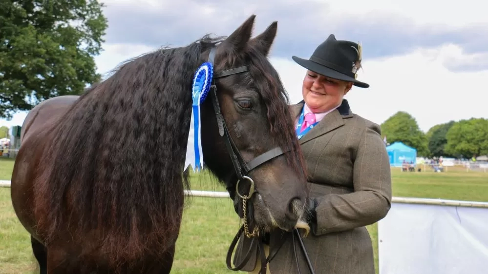 Redwings Edward with his Guardian Claire at a horse show. Edward has won a rossette.