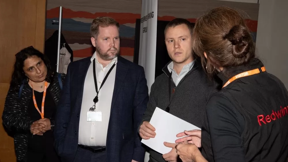 A group of four people are in discussion at the MP drop-in event.