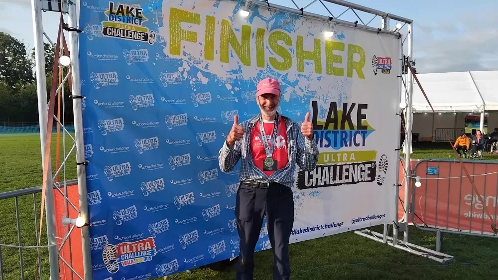 Photo of Ian wearing his finishers medal at the end of the Lake District ultra challenge. 