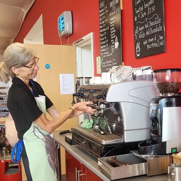 A volunteer making coffees at our Aylsham cafe