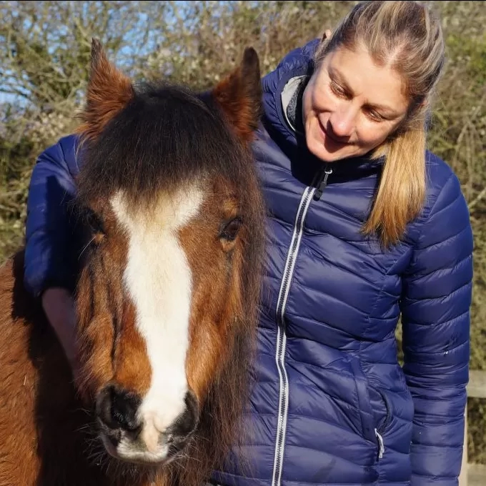 A pony named Aero is cuddled by Redwings Equine Behaviour Manager Sarah Hallsworth.