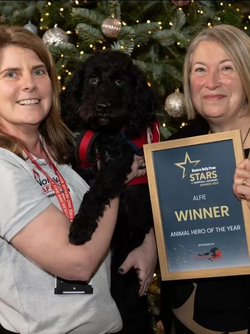 Alfie the dog and his handler pose with Lynn Cutress of Redwings