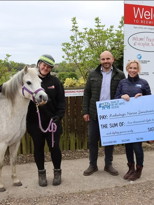 Poppy and husband Nick presenting a cheque
